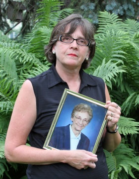 Mary Brennan Taylor holding a portrait of her mother, Alice Brennan. 