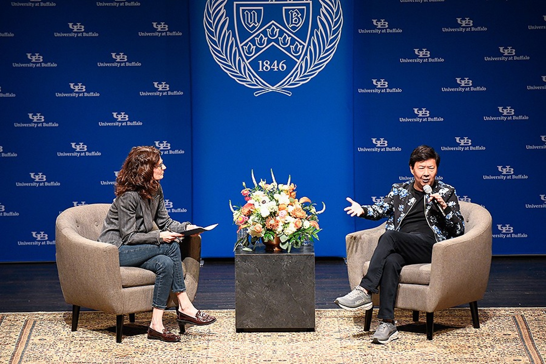Ken Jeong on stage during his lecture with Beth Del Genio to UB President Satish Tripathi. 