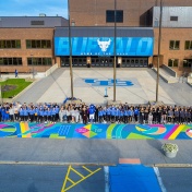 All of the athletes affected by Title IX pose together near the new mural. 