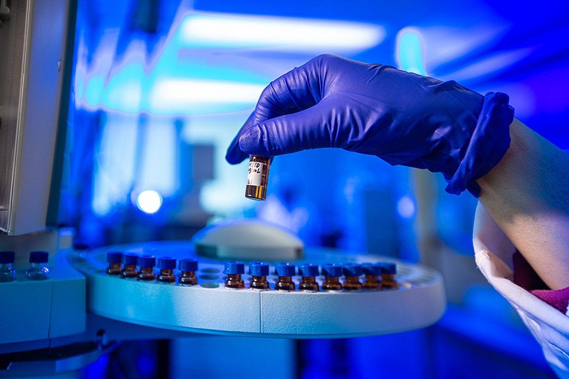 Analytical Toxicology Lab, close up of a gloved hand holding a vial.