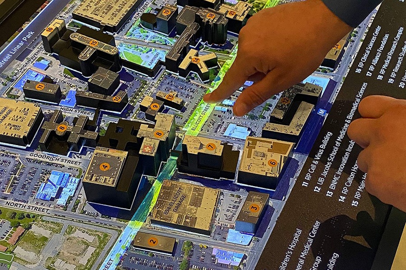 Detail view of a hand touching part of the BNMC touch map. 