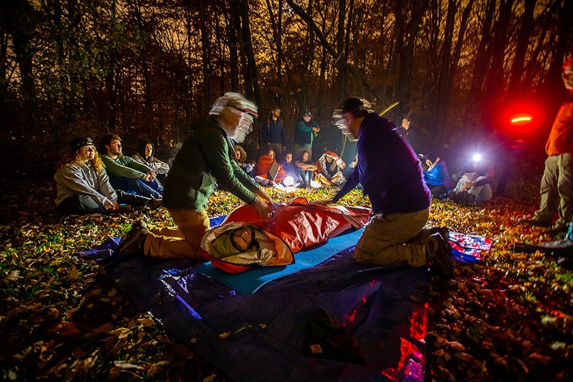 Zoom image: On a fall November evening, the class examined and learned how to preliminarily treat chest wounds. Here, Crispell is demonstrating how to help warm a person injured in the wilderness. Photo: Douglas Levere 
