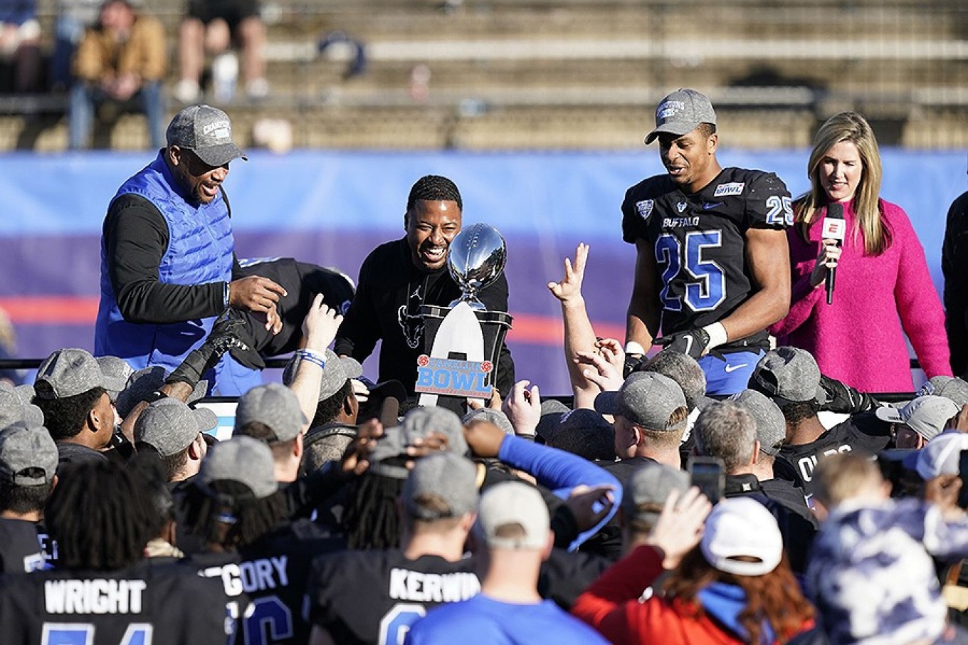 Coach Mo Linguist holds up the Camellia Bowl trophy following the UB Bulls win. 