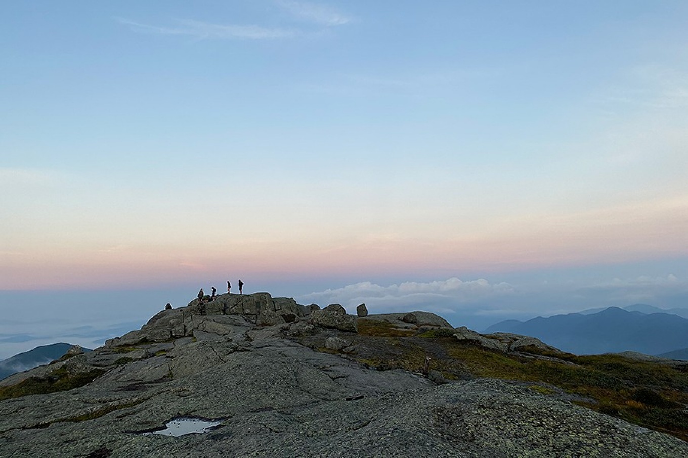 People standing on the summit of a mountain. 
