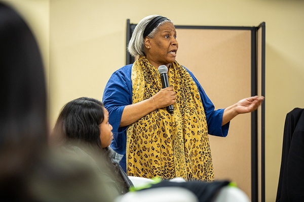A community member named Paula shares her expering during town hall event. 