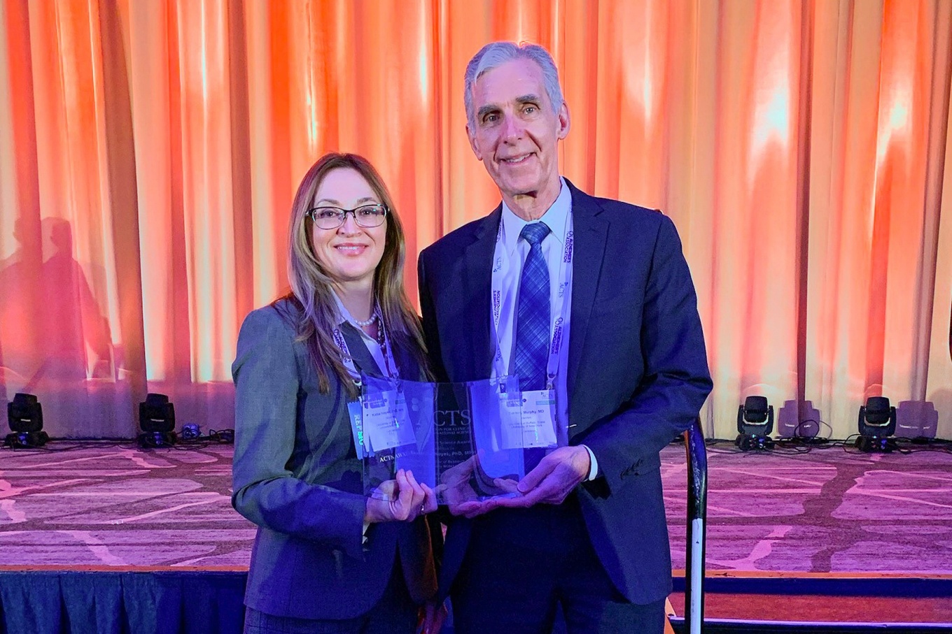 Ekaterina “Katia” Noyes and Dr. Timothy Murphy holding an award. 
