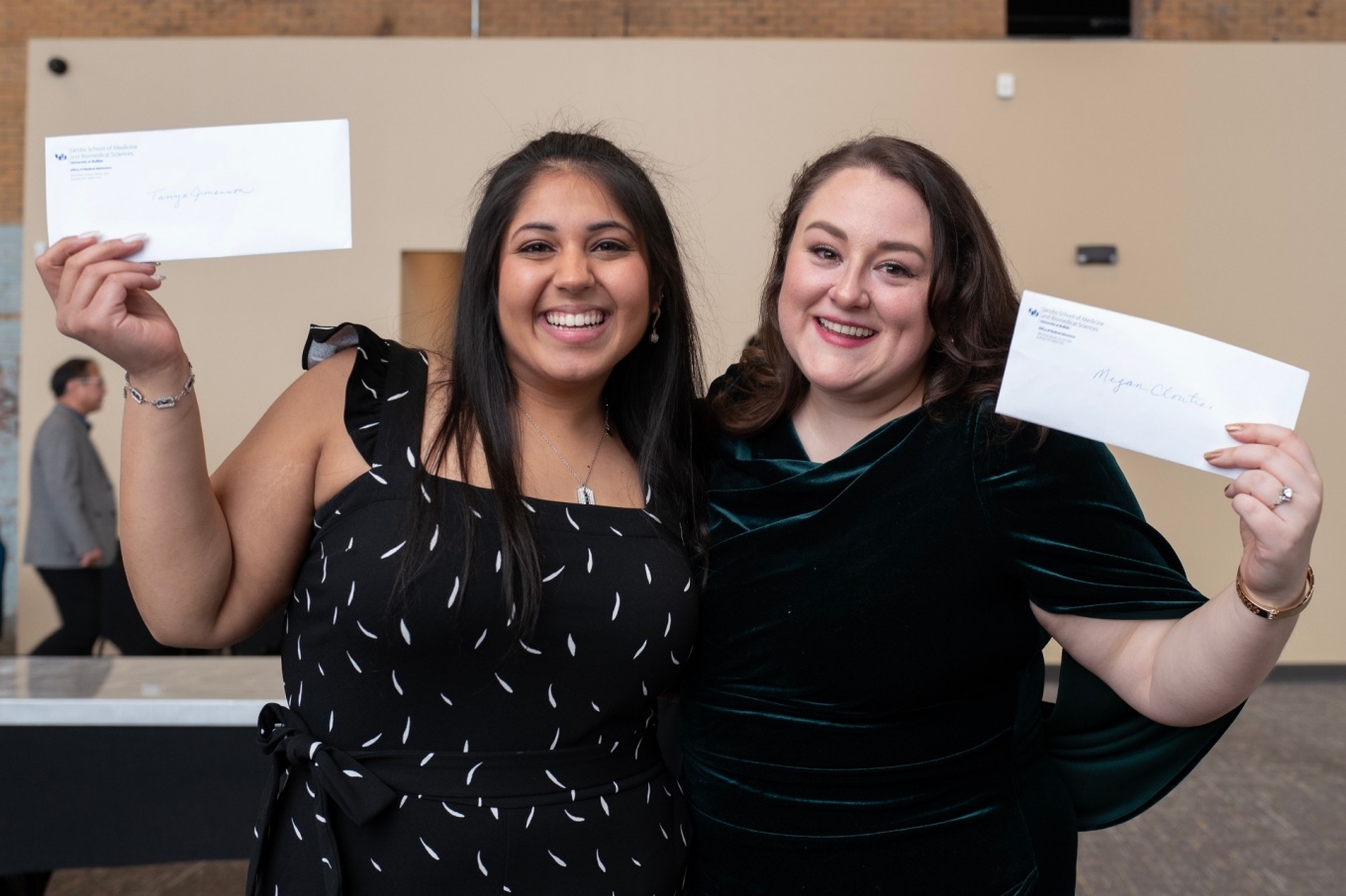 Tanya Verma and Meghan Cloutier hold envelopes notifiying them they have been awarded WNY Medical Scholarships. 