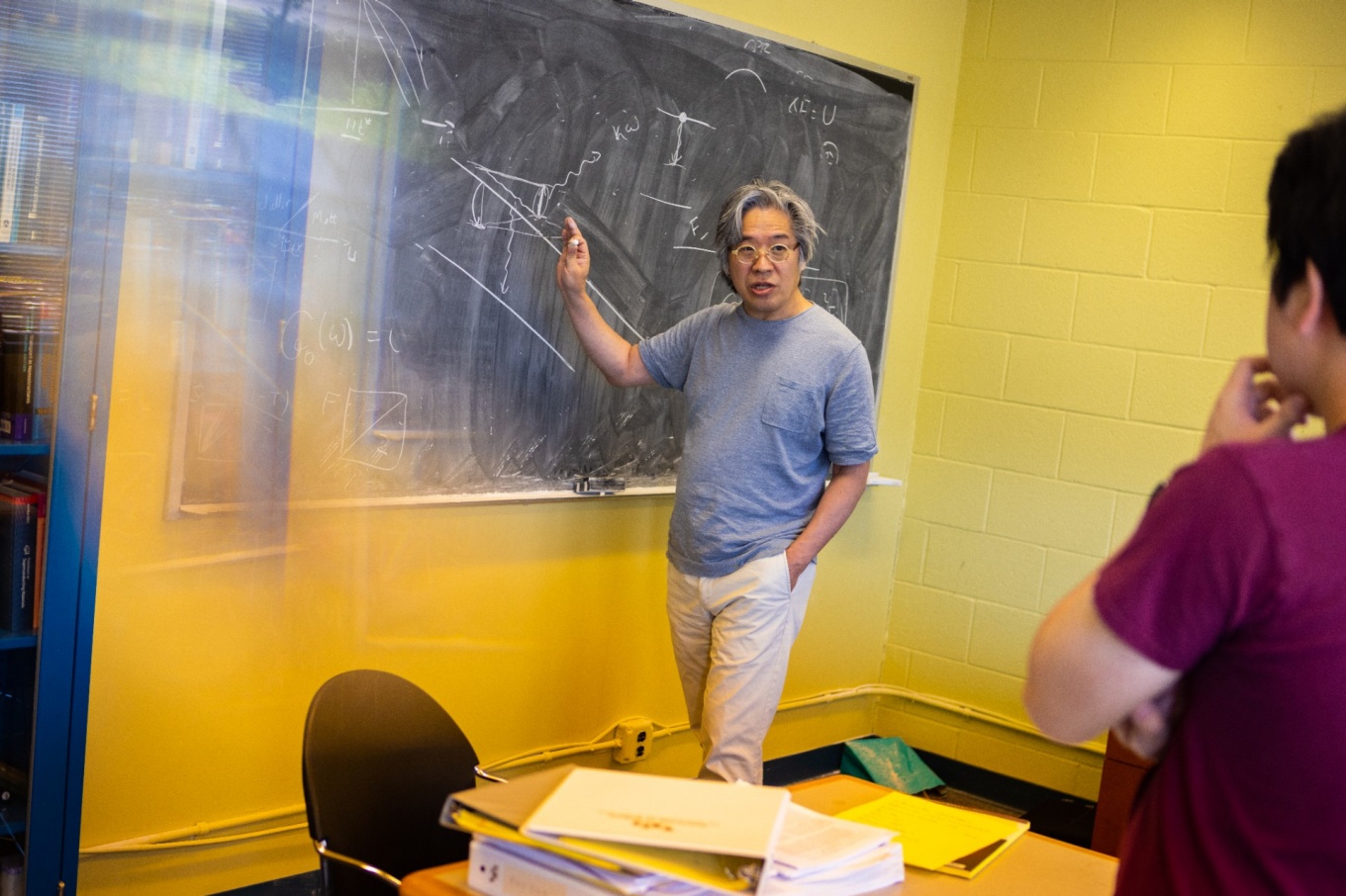 Jong Han illustrates his quantum avalanche theory at the blackboard in his Fronczak Hall office. 