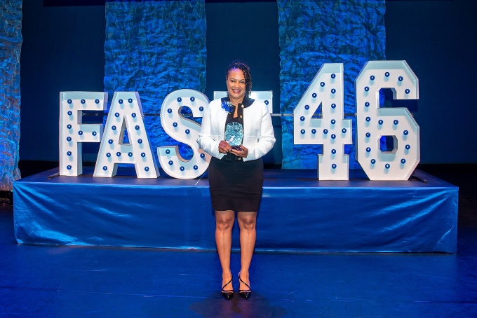 Christian Johnson, winner of the Fast 46 competition, stands on stage holding the award. 