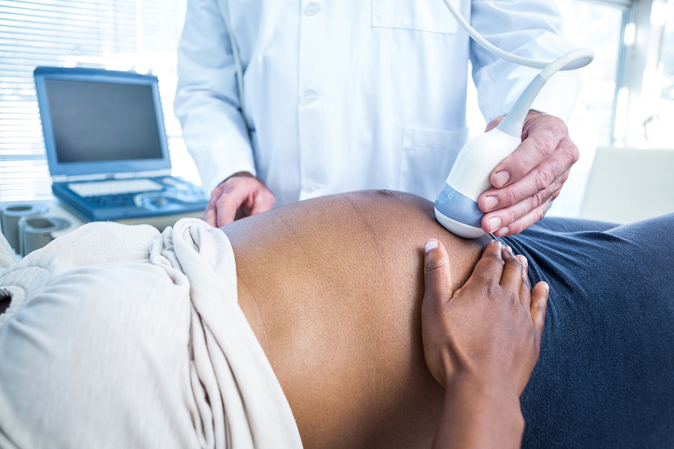 Close up of a pregnant person receiving prenatal care, sonogram. 