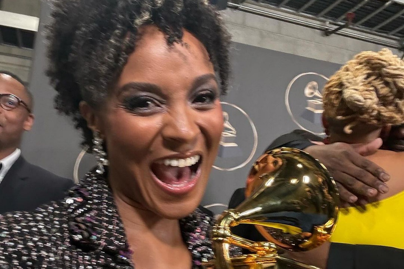 Melissa White smiles exuberantly while holding the grammy she recently won. 