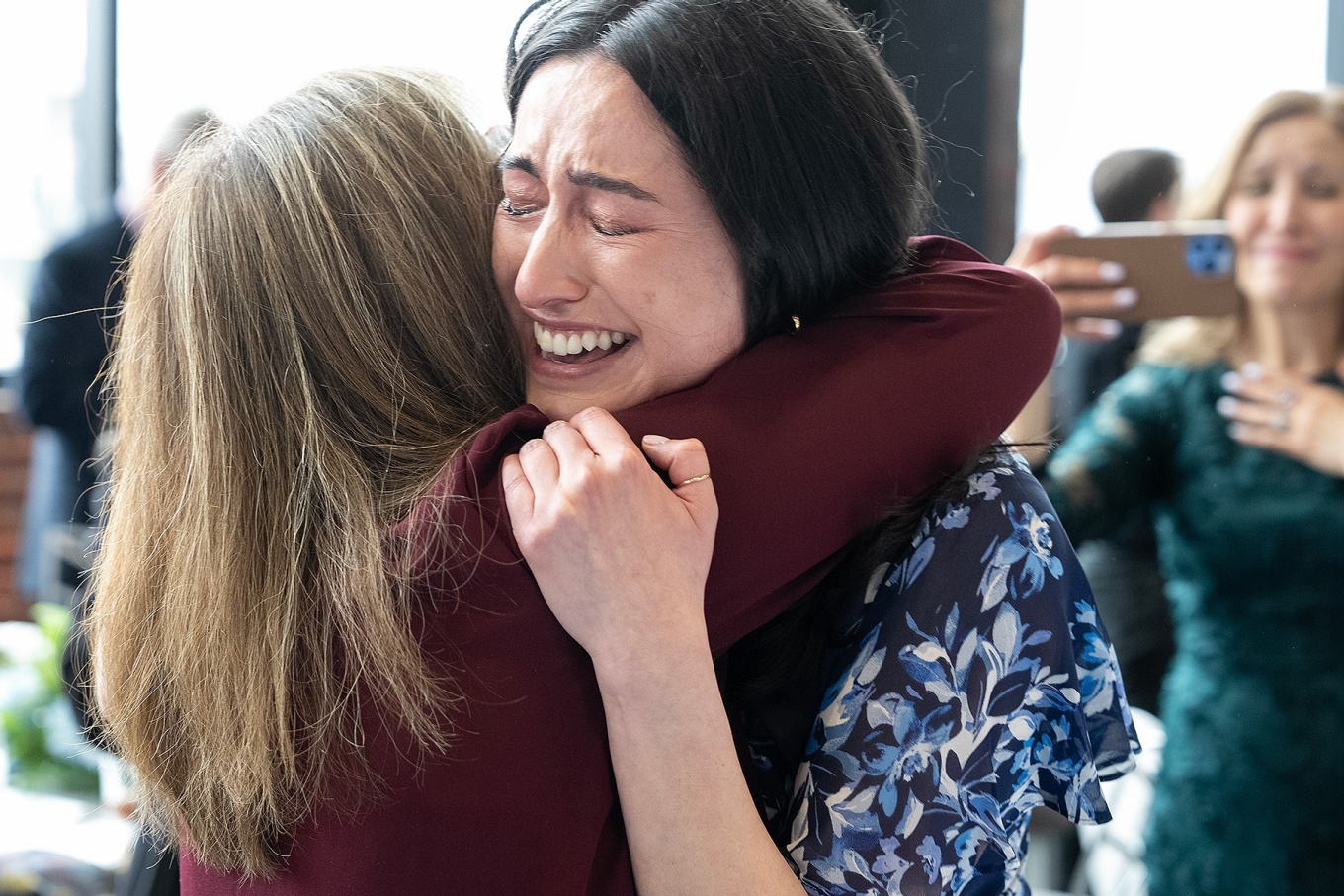 A medical student emotionally hugs another person during a Match Day event. 