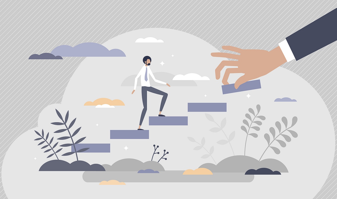 Concept of mentoring featuring a hand placing steps in front of a figure as they climb the steps. 