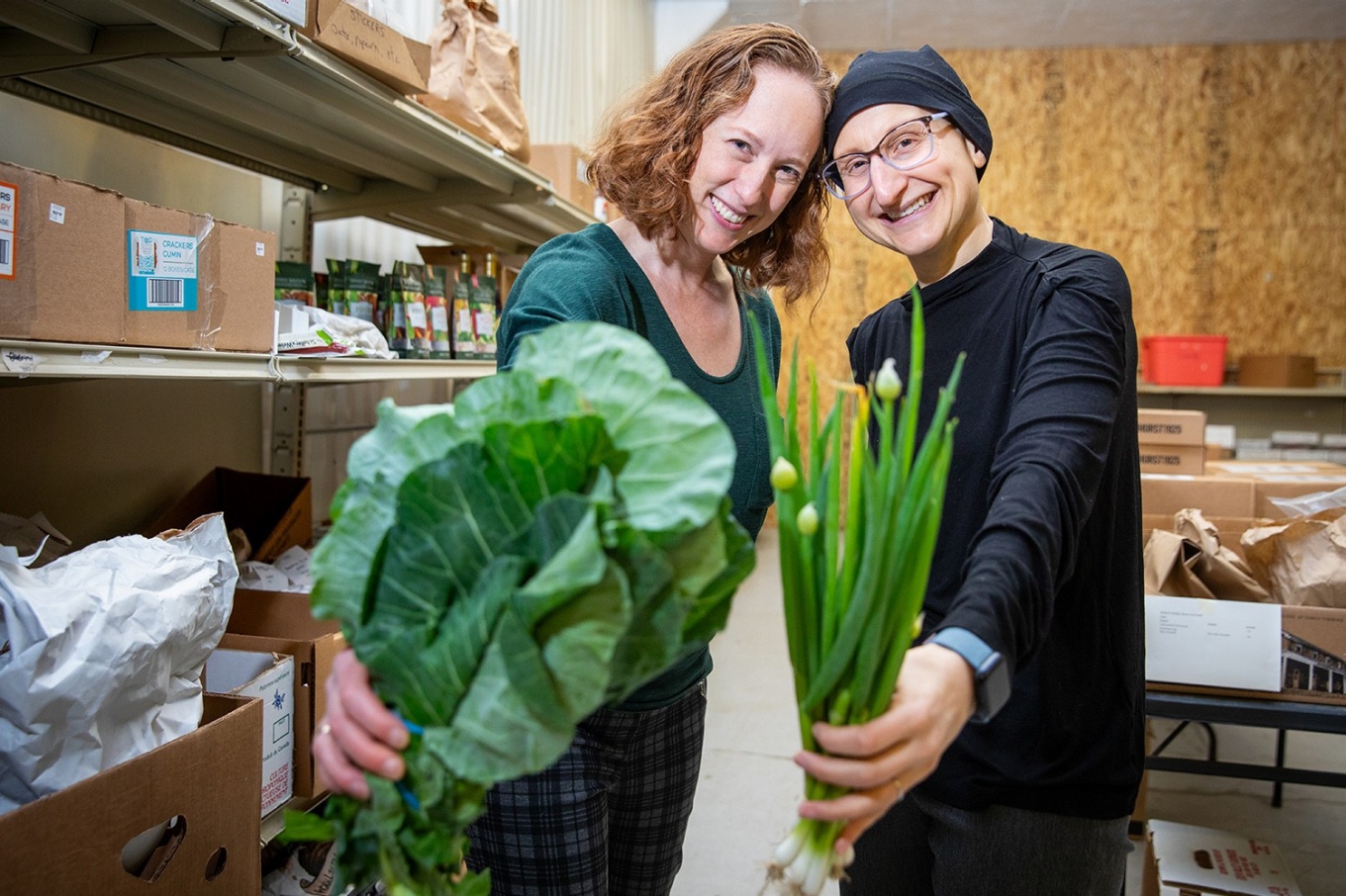 Lucia Leone and Jill Tirabassi hold produce. 
