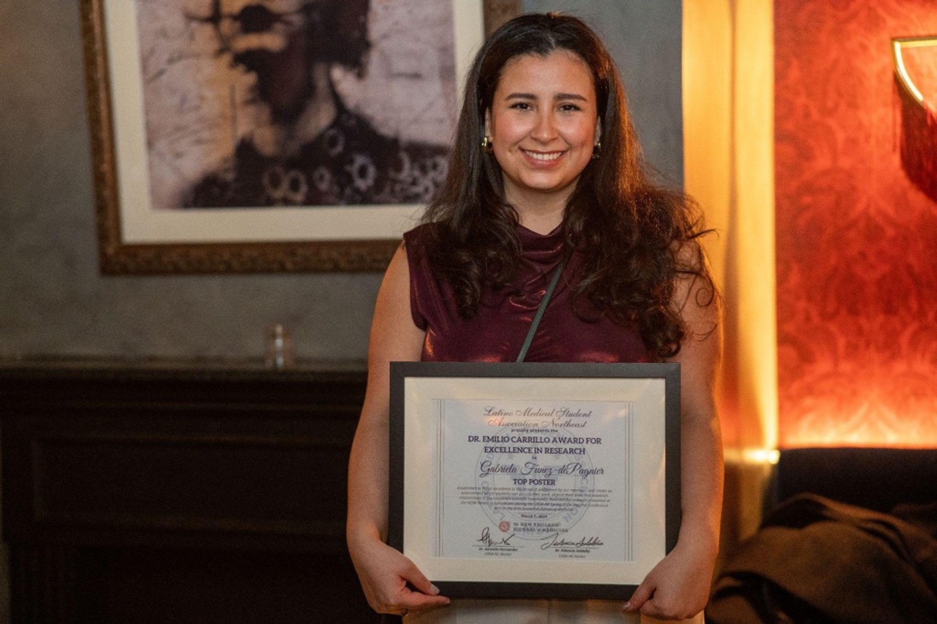 Gabriela Funez-dePaginer holding the Dr. Emilio Carrillo Award for Excellence in Research. 