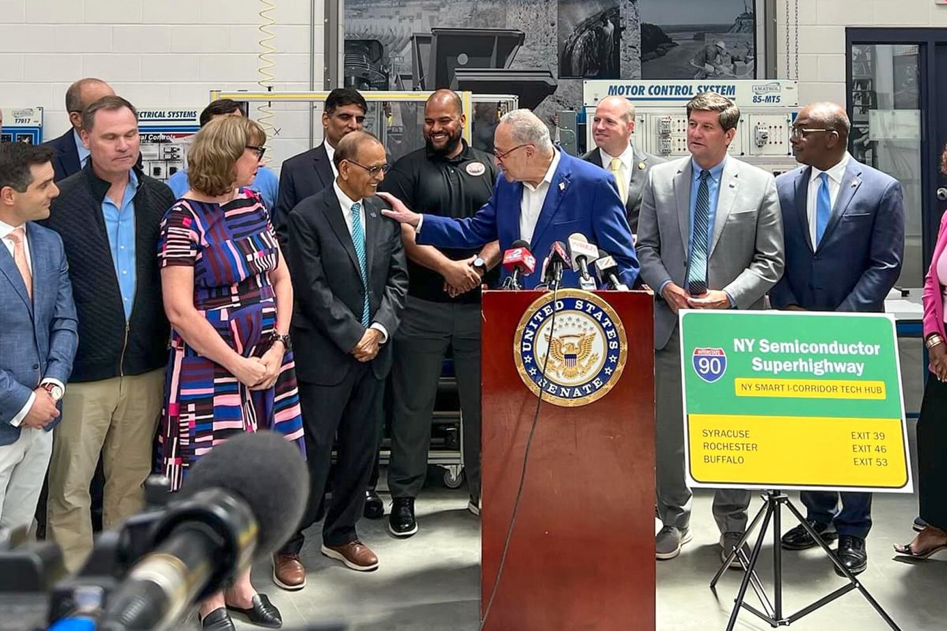 Sen. Chuck Schumer pats President Tripathi on the shoulder during the Tech Hub award press conference. 
