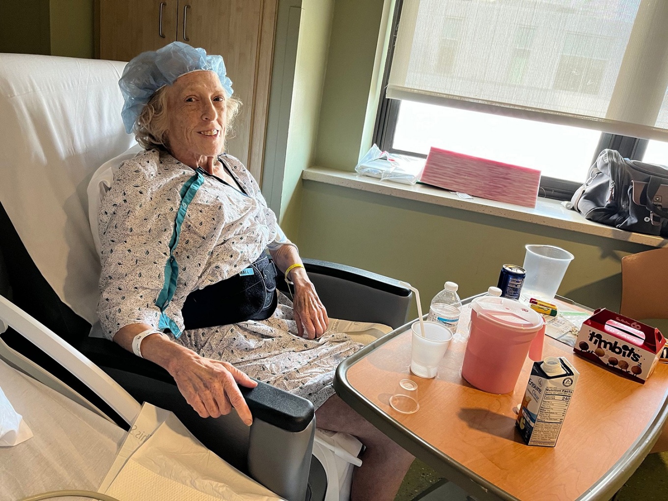 Female patient sitting in a chair in a hospital room. 