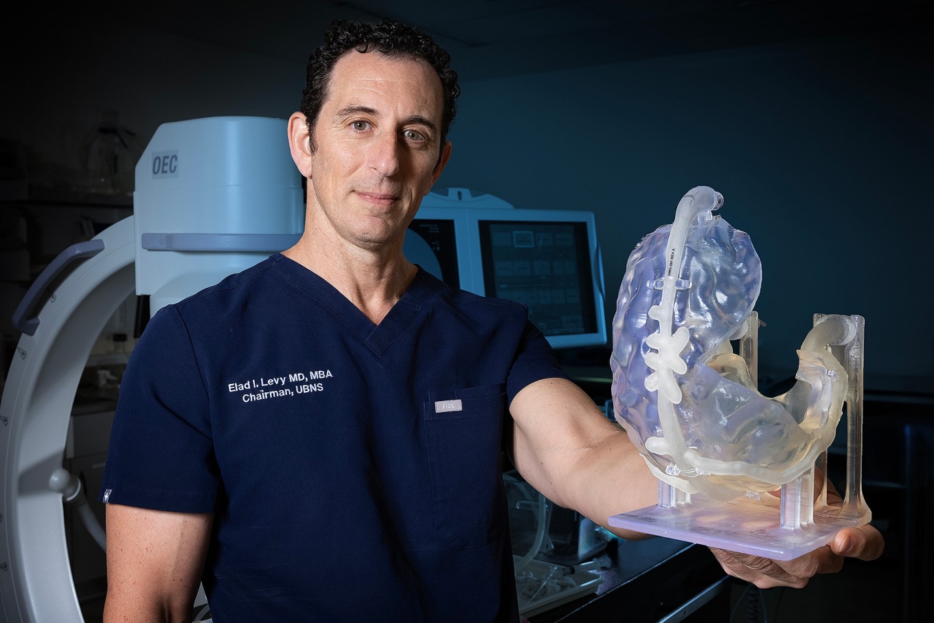 Elad Levy holding 3-D printed model of a patient’s anatomy and vascular structures. 