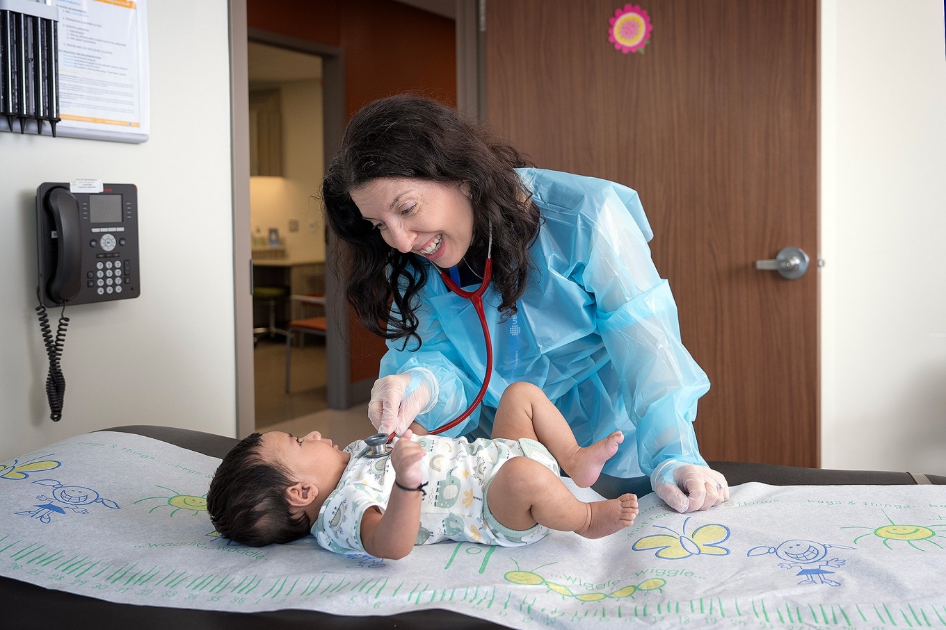 Danielle Goetz examining a baby in a doctor's office. 