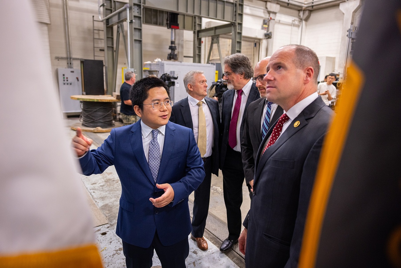 A person speaking to another while explaining a piece of equipment. 