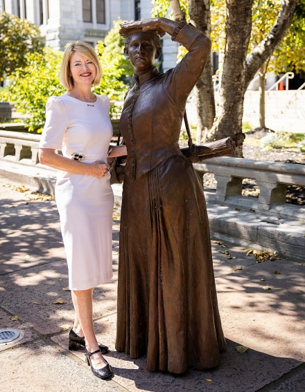 Kelly Hayes-McAlonie posing with a statue of Louise Blanchard Bethune. 