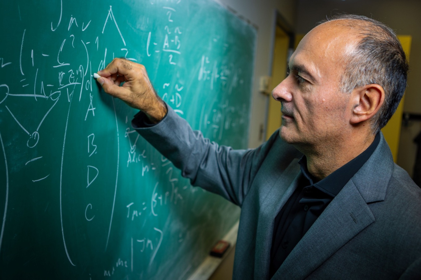 Dejan Stojkovic writing on a chalkboard. 