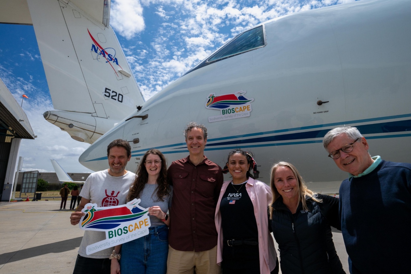 Researchers standing in front of a plane. 