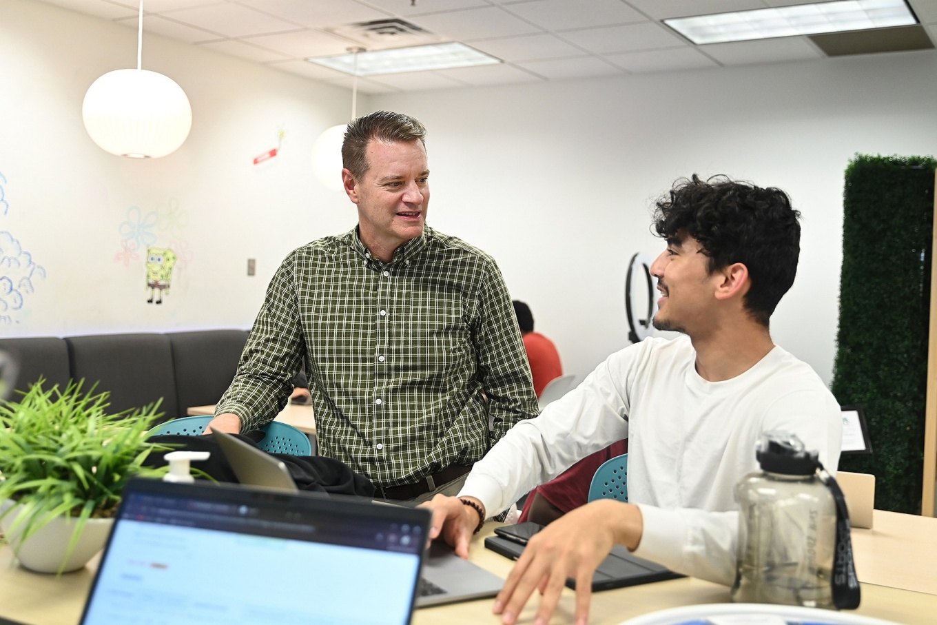 Steven Simpson pictured in the Career Design Center speaking with a student. 