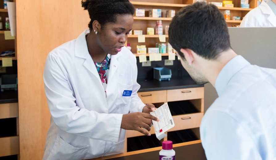 Two people look at a piece of paper. 